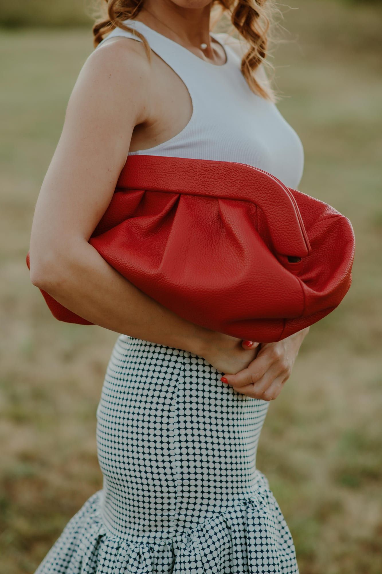 Crvena PELEZZE pouch tašna nošena ispod ruke u polju