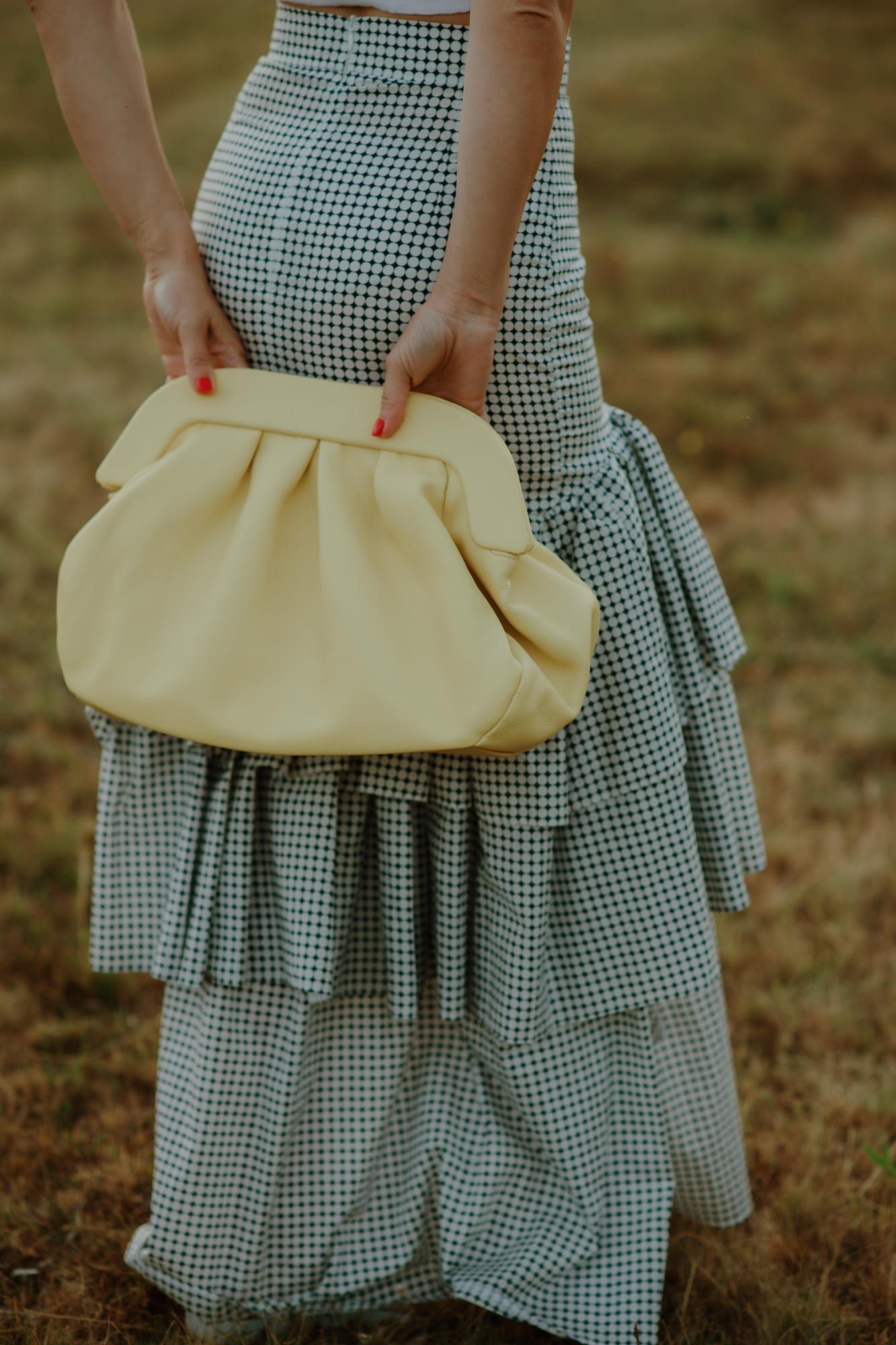 Žuta PELEZZE pouch tašna držana ispred gingham suknje